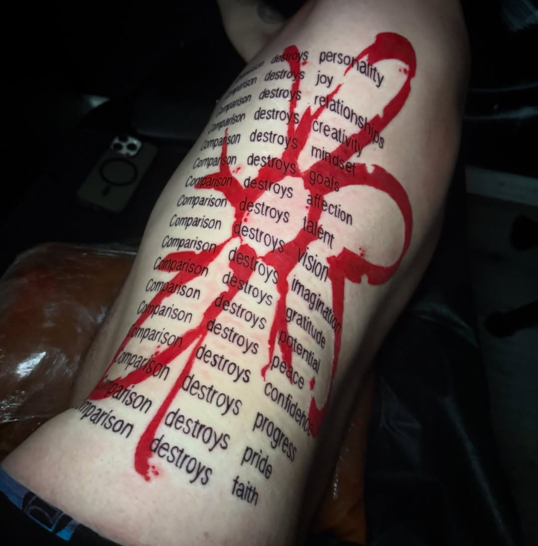 Repeating typewriter-style lettering on the thigh with a single bold red gothic mark slashed across it.